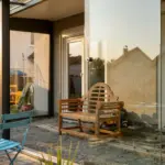 Kompakter Kaltwintergarten in Anthrazit mit geöffneter Ganzglasschiebeanlage und Blick in den Garten