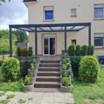 Klassische Terrassenüberdachung mit Polycarbonat-Eindeckung in Opal an Einfamilienhaus